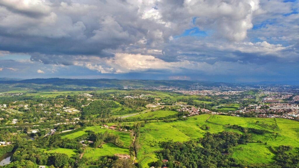 Idyllic aerial view of Campinas countryside with lush greenery and dramatic skies.